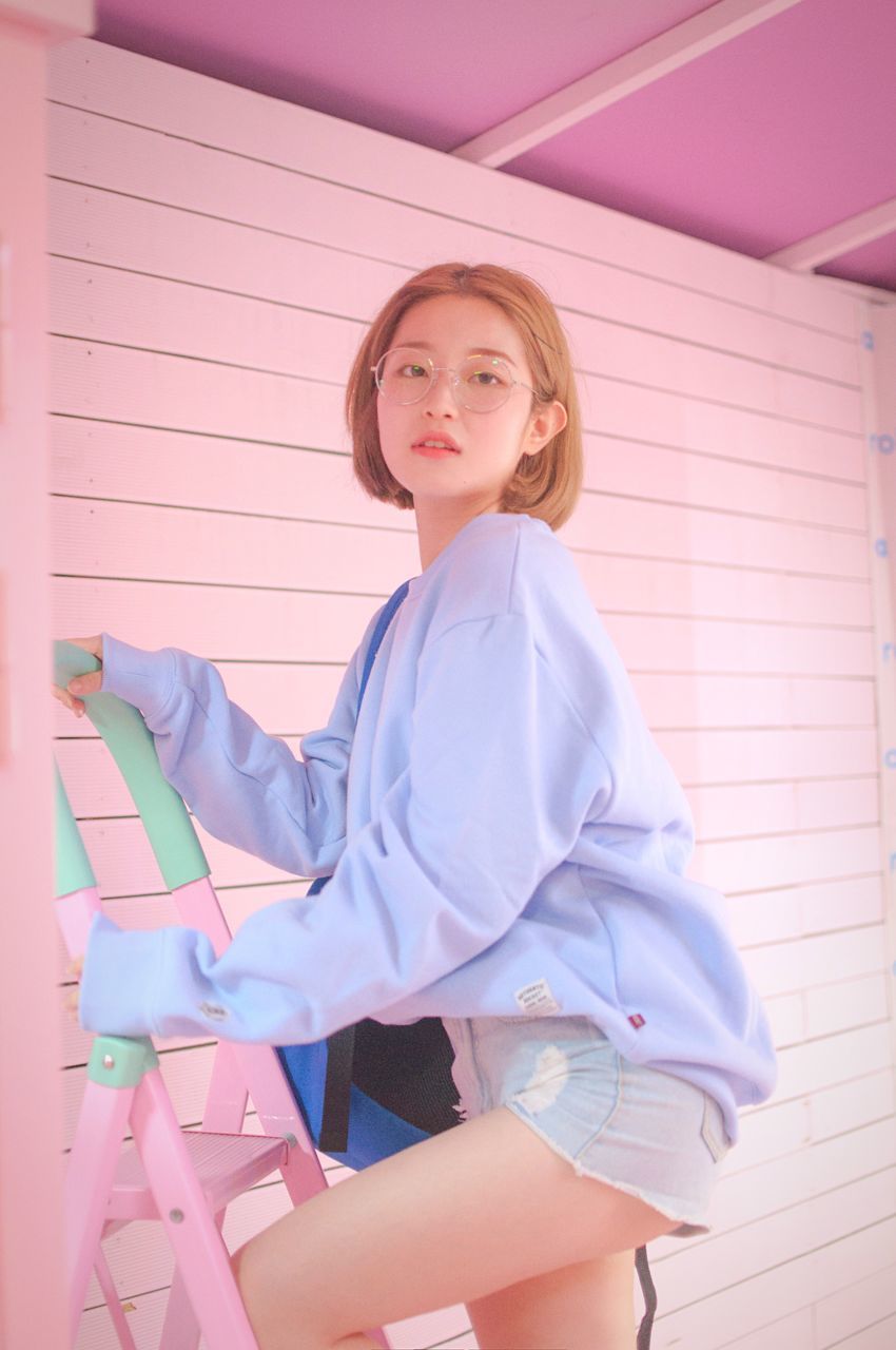 PORTRAIT OF HAPPY GIRL STANDING AGAINST PINK WALL