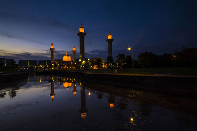 Reflection of illuminated building in puddle at night