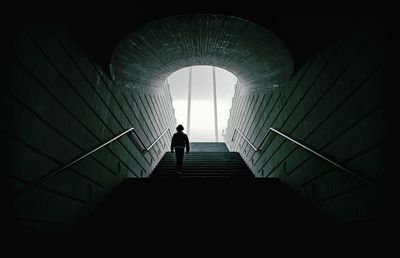 Low angle view of man walking on steps in tunnel