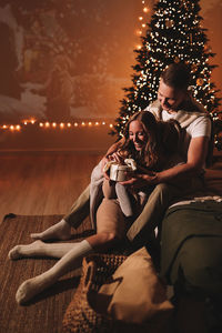 A romantic couple in love celebrates christmas holidays and new year in a cozy house at night