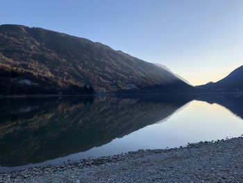 Scenic view of lake and mountains against clear sky