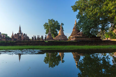 Reflection of temple on building against sky