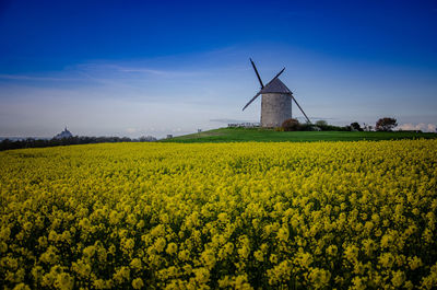 Traditional windmill on field against sky