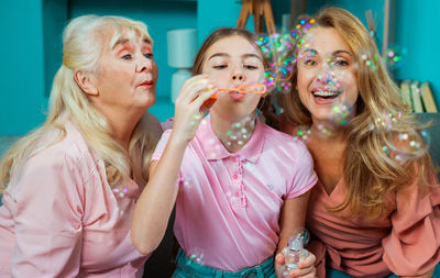 Cheerful family blowing bubbles at home 