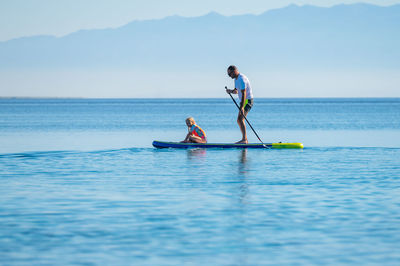 Man surfing in sea against sky