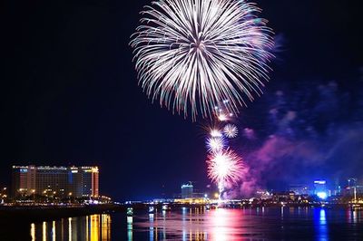 Firework display over river at night