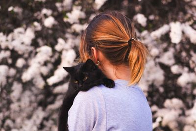 Portrait of woman with cat outdoors