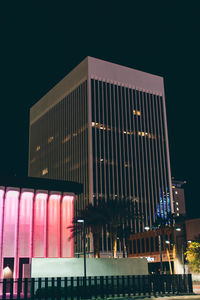 Low angle view of illuminated building against sky at night