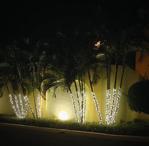 Illuminated street light against sky at night