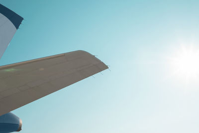 Low angle view of airplane flying against clear blue sky