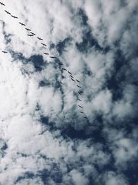 Low angle view of silhouette airplane flying against sky