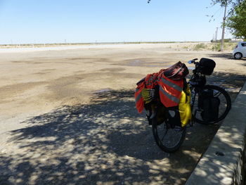 Bicycle on sand against clear sky