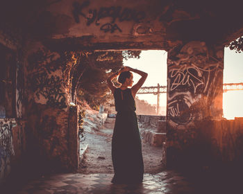 Rear view of woman standing in abandoned building