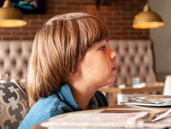 Close-up of boy looking away at home