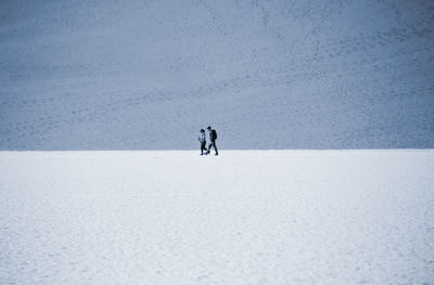 People walking on snow covered land