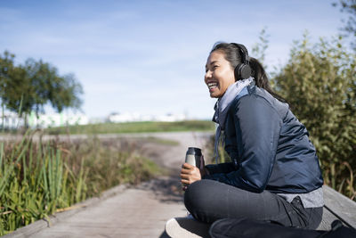 Young woman relaxing on wooden bench