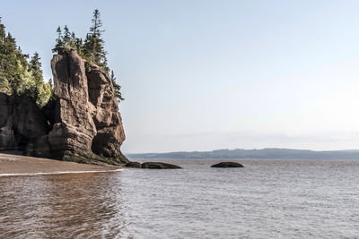 Rock formation in sea against sky