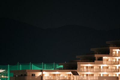 Houses in city against clear sky at night