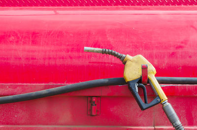 Close-up of fuel pump hanging on red car