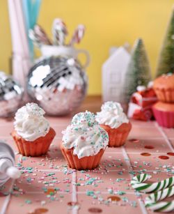 Cupcakes and christmas decorations on pink table, retro style 