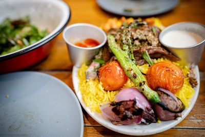 Yellow rice with meat. roasted tomato and onion toppings.