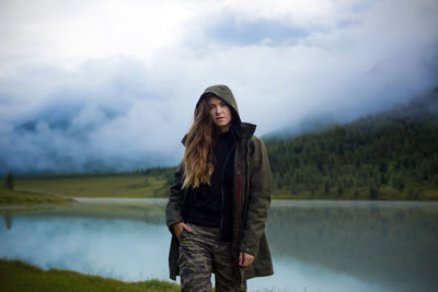 Man standing in lake against sky during winter