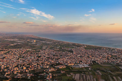 High angle view of townscape by sea against sky