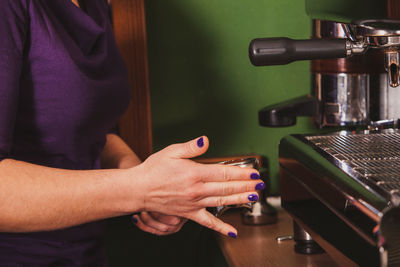Midsection of barista preparing coffee