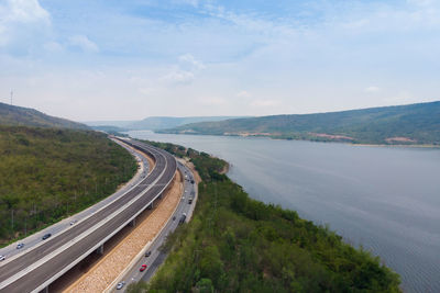 Scenic view of road by mountains against sky