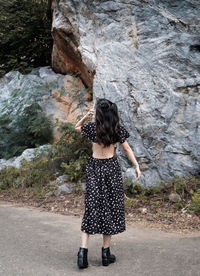 Rear view of woman standing on rock