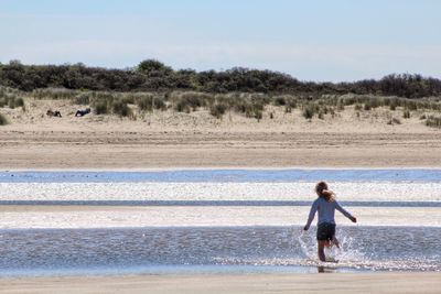 Rear view of girl running on beach