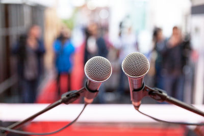 Close-up of microphones with people in background