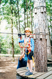 Full length of boy standing in forest