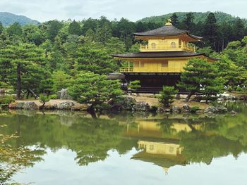 Built structure by lake against trees