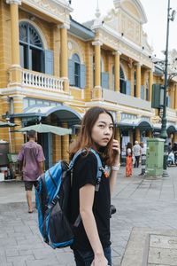 Portrait of young woman standing on street