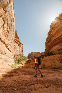 Female hiker walks on a dried river bed in the maze canyonlands utah