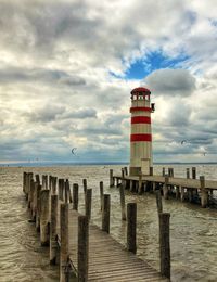 Lighthouse on beach against sky