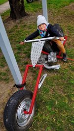 Rear view of boy riding motorcycle on field