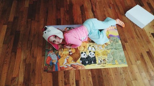 High angle view of girl playing on hardwood floor