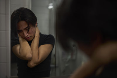 Young man standing in front of mirror