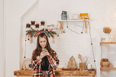 Rear view of woman standing by christmas tree