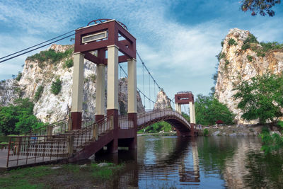 Bridge over river in city against sky