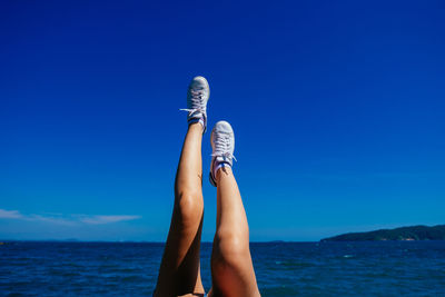 Low section of person against clear blue sky