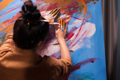 Rear view of woman against graffiti wall