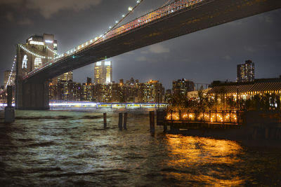 Illuminated bridge over river at night