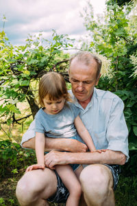 Portrait of boy sitting on field