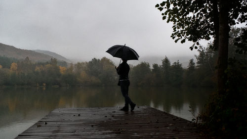 Full length of woman standing in lake during rainy season