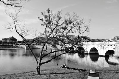 Arch bridge over river against sky
