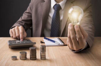 Midsection of man holding camera on table