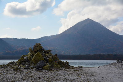 Scenic view of rocks by lake against sky